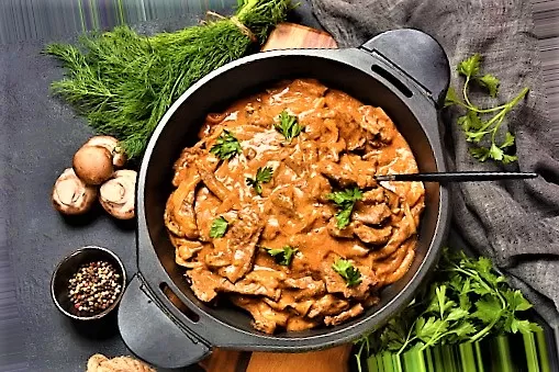Beef stroganoff with cremini and champignons on a frying pan.